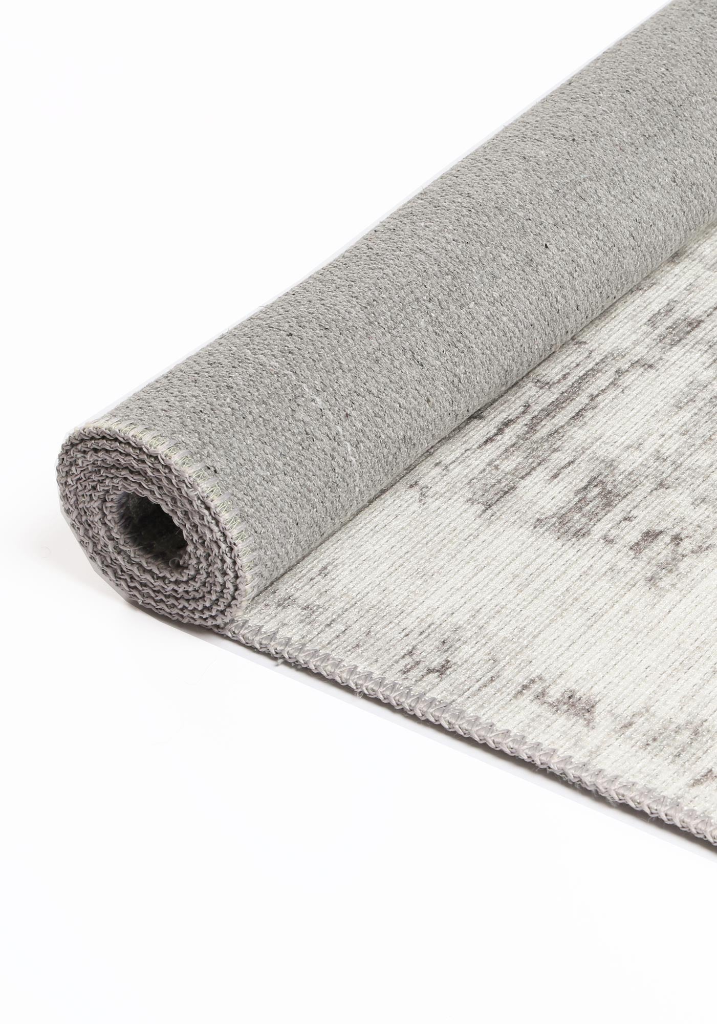 Gray textured rug partially unrolled on a white background