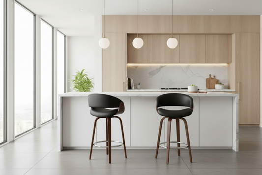 A modern kitchen island with two dark wood bar stools, set in a bright, contemporary kitchen with light wood cabinets, a white marble backsplash, and large windows.