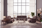 Brown leather sofa set in a modern living room with large windows.
