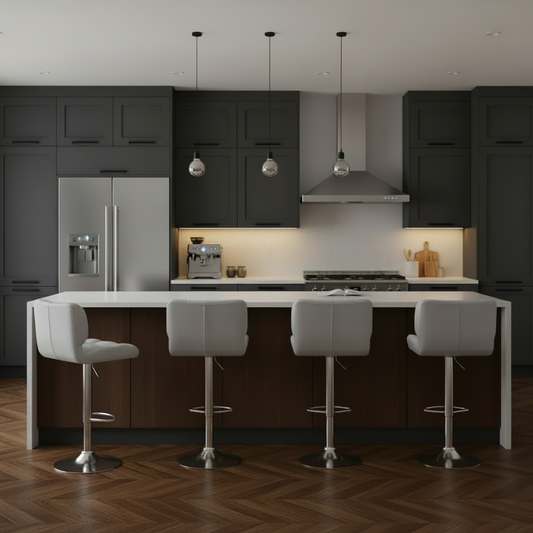A modern kitchen interior with dark charcoal cabinets, a white countertop, a wood-look island base, stainless steel appliances, pendant lights, and four white bar stools arranged around the island on a herringbone wood floor.