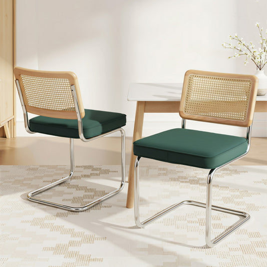 Two green cushioned chairs with wooden backrests in a room setting.