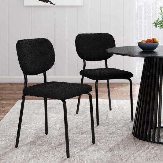 Two black chairs in a room with a table and decorative elements.