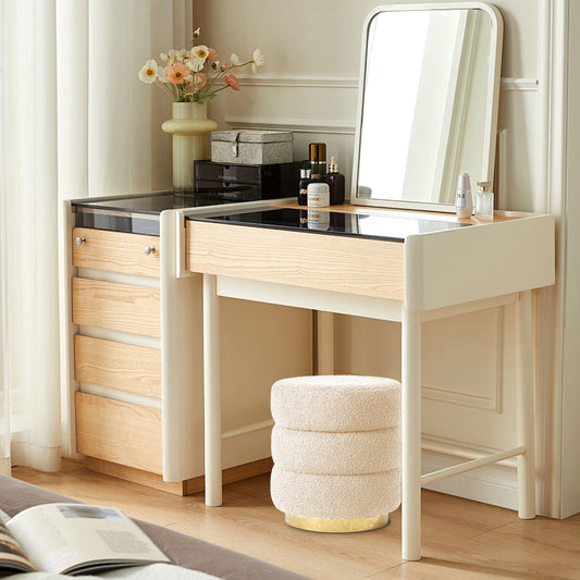 Dressing table with mirror, drawers, and a stool in a room setting.