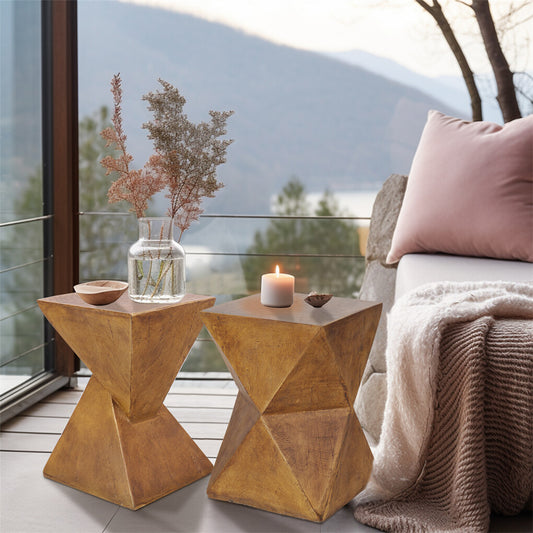 Two geometric wooden side tables with decorative items on a balcony with a mountain view.