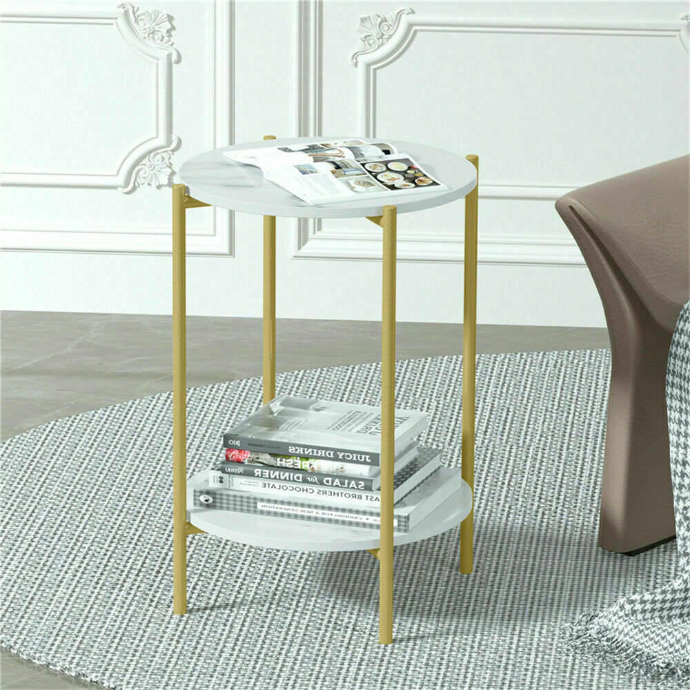 Small round side table with gold legs and white top in a room setting.