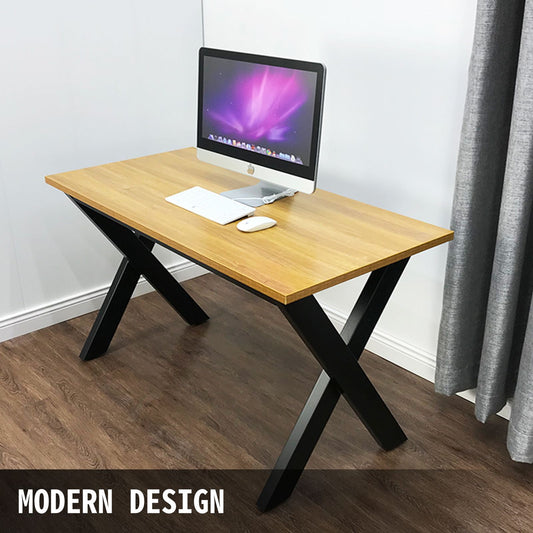 Wooden desk with black metal legs featuring a computer setup in a room.