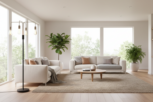 Modern living room with white sofas, a coffee table, floor lamp and decorative plants.