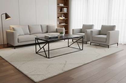 Modern living room with gray sofa, armchairs, and a coffee table on a light rug.