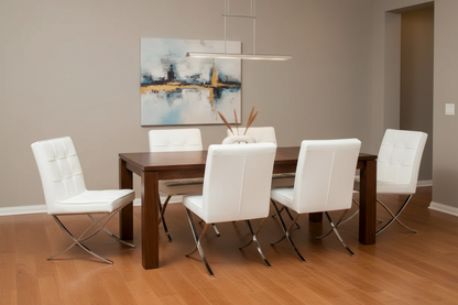 A modern dining room setup featuring a dark wood rectangular table surrounded by six white leather chairs with chrome legs, set against a warm gray wall with a framed abstract painting.